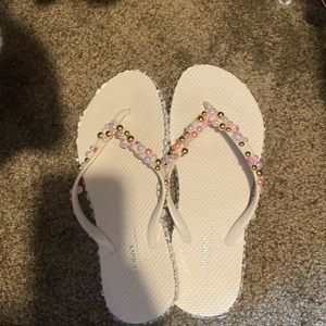 White bejeweled flip flops